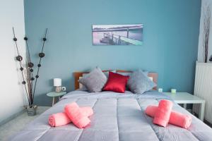 a bed with pink and gray pillows on it at PK Luxury Apartment, feels like home in Alexandroupoli