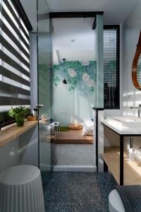 a bathroom with a glass shower and a sink at Ho.Me-Easyhouse -II in Tainan