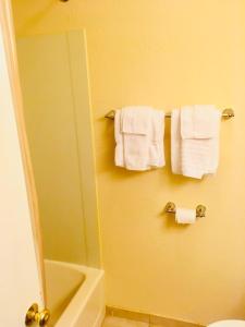 a bathroom with a mirror and towels on a rack at Anchorage Inn Rochester in Rochester