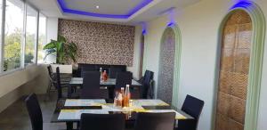 a dining room with tables and chairs and windows at Cess Summer Boutique Hotel in Kalibo