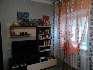 a living room with a television and a window at Apartments on Samal 1 in Almaty