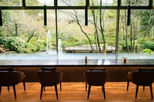 een bar met stoelen en uitzicht op een fontein bij Hotel Kamogawaso in Takekara