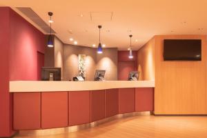 a lobby with a bar with a flat screen tv at E Hotel Higashi Shinjuku in Tokyo