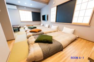 a room with four beds with pillows in it at MEIBI Hakone Yumoto in Hakone