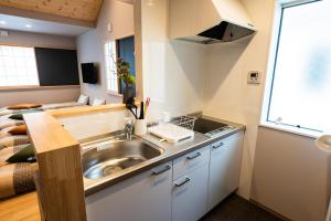 a kitchen with a sink in a small room at MEIBI Hakone Yumoto in Hakone