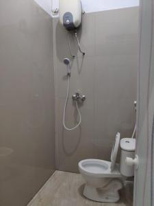 y baño con ducha y aseo. en Hotel Boegenviel Syariah, en Lamongan