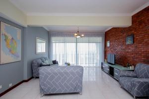 a living room with a couch and a tv at Fun Apartment @ Equatorial Hill Resort in Cameron Highlands +10 photos