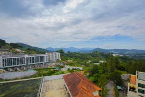 an overhead view of a building with mountains in the background at Fun Apartment @ Equatorial Hill Resort in Cameron Highlands