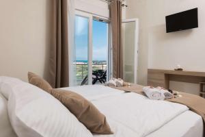 a bedroom with a bed with towels and a window at Maria's Sea View Villa in Skala Rachoniou