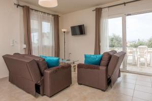 a living room with two chairs and a table at Maria's Sea View Villa in Skala Rachoniou