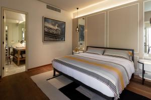 a bedroom with a large bed and a bathroom at Central Hotel Boutique in Chihuahua