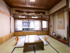 a room with a table and two chairs and a window at Ikariya Ryokan in Yamanouchi