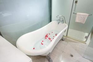 uma banheira branca com corações vermelhos na casa de banho em Lavande Hotel Beijing Asian Games Village em Pequim