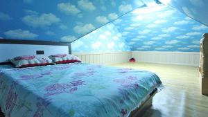 1 dormitorio con 1 cama grande y techo azul en Tongyeong Bada Sarang Pension, en Tongyeong