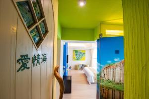 a hallway with a room with green walls and a cat on the floor at Indigo Homestay in Magong