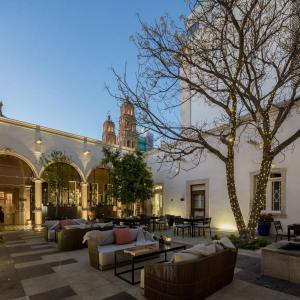 a courtyard with couches and tables and a building at Central Hotel Boutique in Chihuahua