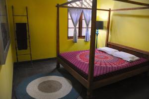 a bedroom with a bed with a wooden frame and a window at Villa Buddha Malioboro in Yogyakarta