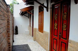 an alley with a red door and a brick wall at Villa Buddha Malioboro in Yogyakarta