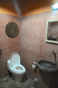 a bathroom with a toilet and a bath tub at Villa Buddha Malioboro in Yogyakarta