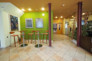 a room with stools and a green wall at Hotel Montserrat in Sitges