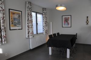 Un comedor con una mesa y sillas negras. en Villa KARIN, en Oostduinkerke