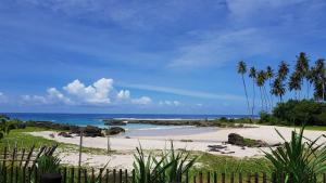 a sandy beach with palm trees and the ocean at Kita Surf Resort in Lasikin