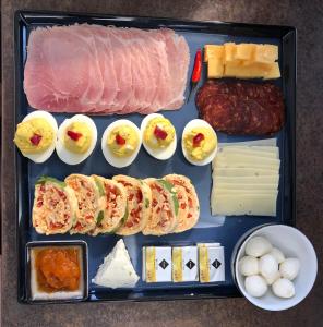 a tray of food with meat eggs cheese and sausage at Herbstyle in Eger