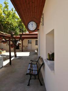 einer Bank, die unter einer Uhr auf der Seite eines Gebäudes sitzt in der Unterkunft Lemon Tree Courtyard in Larnaka