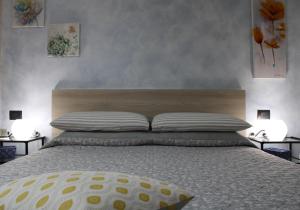 een slaapkamer met een groot bed met 2 lampen bij Blu Panorama belvedere lago di Como in Varenna