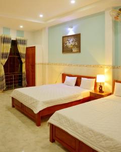 a bedroom with two beds and a lamp in it at Vien Duong Hotel in Quy Nhon