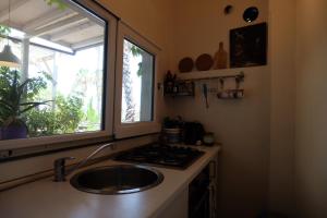 cocina con fregadero y ventana en Villa Cavallaro, en Aci Trezza