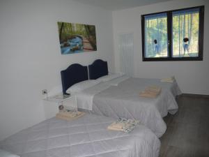 a room with three beds and a window at "CARA PACE" in collina - Guest House in Montefiore Conca