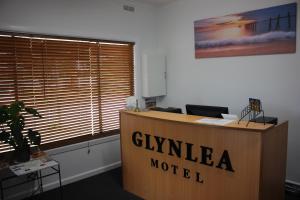un escritorio en una oficina con un cartel de motel Gillian en Glynlea Motel en Horsham