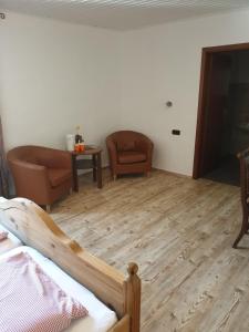1 Schlafzimmer mit einem Bett, 2 Stühlen und einem Tisch in der Unterkunft Gastehaus in der Alte Kellerei in Kobern-Gondorf