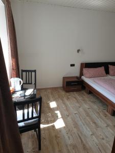 ein Schlafzimmer mit einem Bett, einem Tisch und einem Stuhl in der Unterkunft Gastehaus in der Alte Kellerei in Kobern-Gondorf