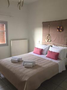 1 dormitorio con 1 cama grande con almohadas rosas y blancas en Mommy's House, en Angeliana