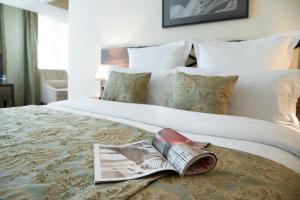 een hotelkamer met een bed met een tijdschrift erop bij Ani Plaza Hotel in Jerevan