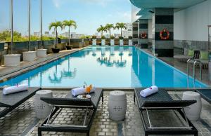 a large swimming pool with two tables and chairs at Muong Thanh Luxury Song Han Hotel in Da Nang