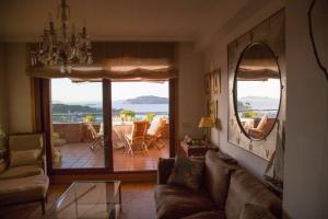 ein Wohnzimmer mit einem Sofa und einem großen Spiegel in der Unterkunft Inmejorables vistas a las islas Cies in Baiona