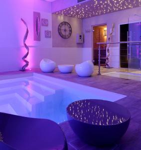 a room with a pool with chairs and a table at Grand Hôtel des Bains SPA in Fouras