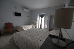 ein Schlafzimmer mit einem Bett, einer Lampe und einem Fenster in der Unterkunft Locazione Turistica Domus Re in Agrigento