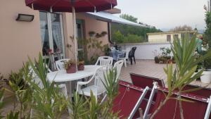 a patio with a table and chairs and an umbrella at Guest House Attico Della Vittoria in Gabicce Mare