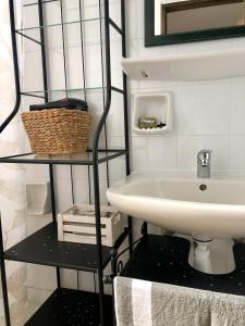 a bathroom with a sink and a shelf with a basket at Nicolas Beach in Palaiochora