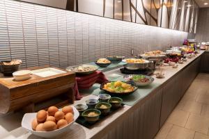 una línea de buffet con muchos platos de comida. en Hotel Binario Umeda, en Osaka