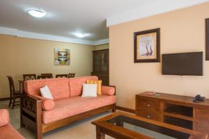 ein Wohnzimmer mit einem Sofa und einem Flachbild-TV in der Unterkunft Aparthotel El Galeón in Santa Cruz de la Palma