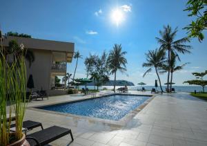ein Swimmingpool mit Blick auf das Meer in der Unterkunft Frangipani Langkawi Resort in Pantai Cenang