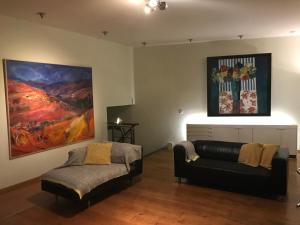 a living room with a couch and a painting on the wall at The Art Residence Maastricht in Maastricht