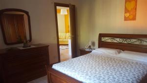 sypialnia z łóżkiem, komodą i lustrem w obiekcie Casa Monaco w mieście Auletta