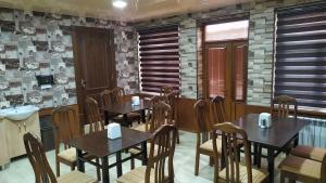a restaurant with tables and chairs in a room at Alisher B&B Hotel in Samarkand