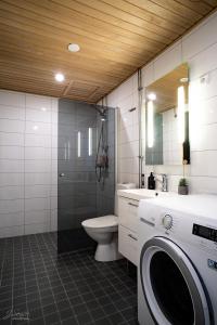 a bathroom with a toilet and a washing machine at Westbay Inn in Vaasa